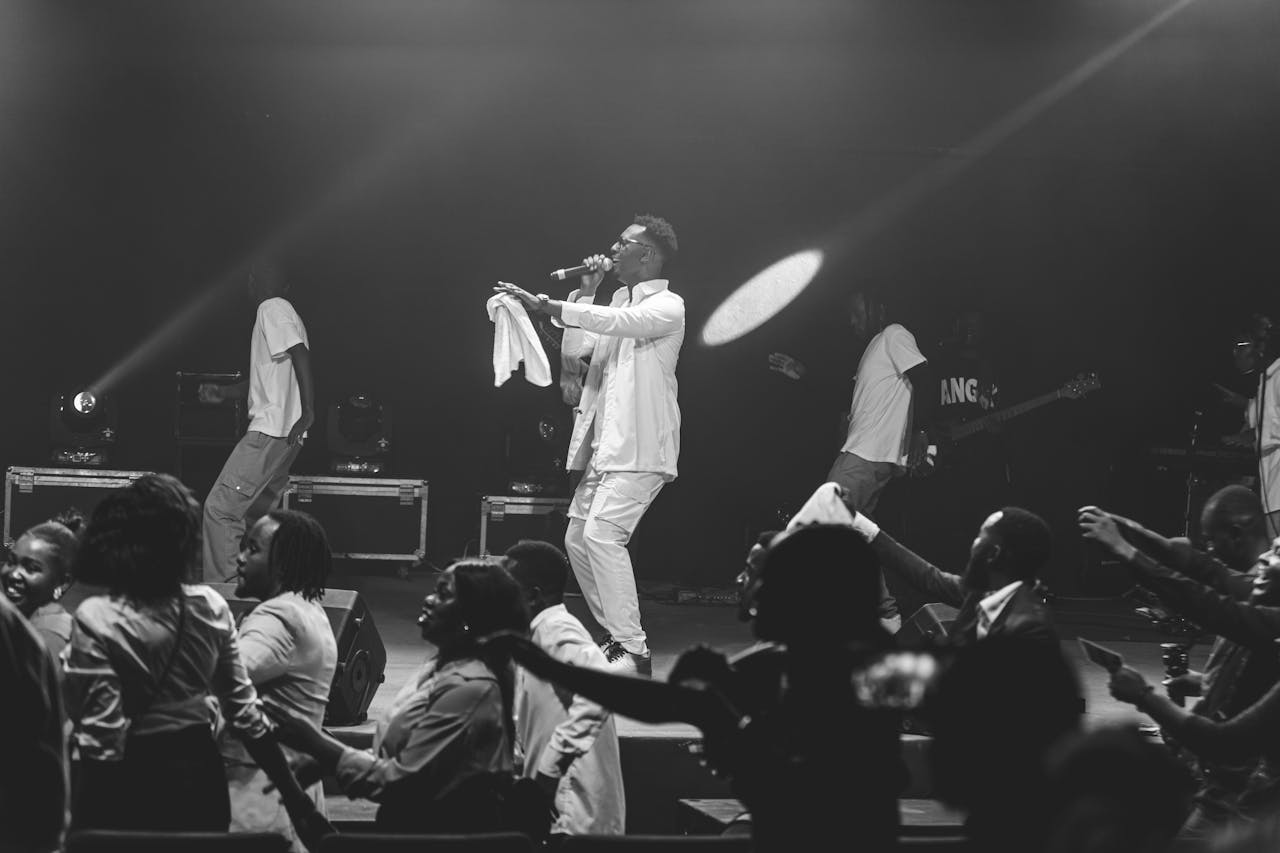Black and white image capturing a dynamic live music performance on stage.